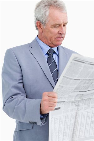 Mature tradesman reading the news paper against a white background Stock Photo - Budget Royalty-Free & Subscription, Code: 400-06634321