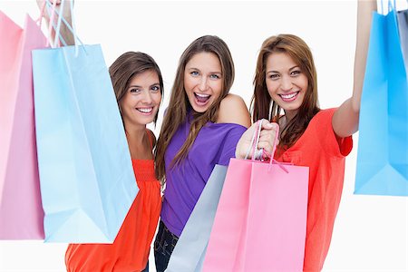 simsearch:400-06634629,k - Happy teenagers raising their arms while holding their purchase bags Fotografie stock - Microstock e Abbonamento, Codice: 400-06634593