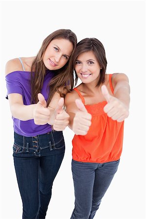 simsearch:400-06634629,k - Teenagers putting their thumbs up with beaming smiles Fotografie stock - Microstock e Abbonamento, Codice: 400-06634626