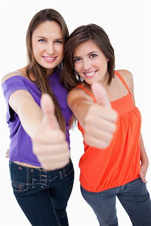 simsearch:400-06634629,k - Teenagers smiling a lot while raising their thumbs up in agreement with focus on the teenagers Fotografie stock - Microstock e Abbonamento, Codice: 400-06634629