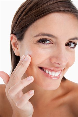 Attractive teenage girl applying moisturizer cream on her face with her fingers Stock Photo - Budget Royalty-Free & Subscription, Code: 400-06634725