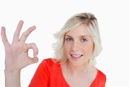 simsearch:400-06635276,k - Woman showing the OK sign in front of the camera against a white background Photographie de stock - Aubaine LD & Abonnement, Code: 400-06634799
