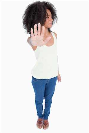 simsearch:400-04213571,k - Young woman with curly hair looking on the side while showing the hand stop sign Foto de stock - Royalty-Free Super Valor e Assinatura, Número: 400-06634998