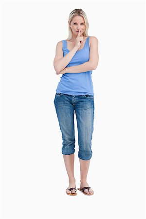 Blonde woman telling to be quiet while crossing arms against a white background Photographie de stock - Aubaine LD & Abonnement, Code: 400-06635026