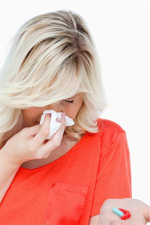 female teenage ill - Woman sneezing while holding red and blue drugs against a white background Stock Photo - Budget Royalty-Free & Subscription, Code: 400-06635182