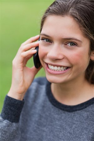 Teenage girl talking with her cellphone while looking straight at the camera Stock Photo - Budget Royalty-Free & Subscription, Code: 400-06635324