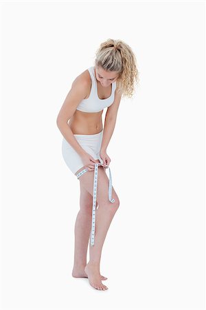 Young blonde woman measuring her thigh in underwear against a white background Stock Photo - Budget Royalty-Free & Subscription, Code: 400-06635365