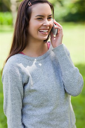 Young girl standing in a parkland while talking on the phone and laughing Stock Photo - Budget Royalty-Free & Subscription, Code: 400-06635431