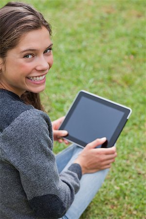 students tablets outside - Young girl using her tablet computer while sitting on the grass and beaming Stock Photo - Budget Royalty-Free & Subscription, Code: 400-06635532