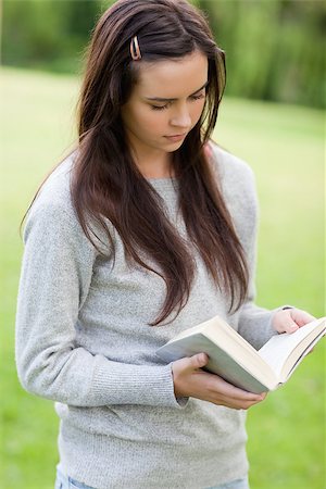 simsearch:400-03923096,k - Serious young girl reading a book while standing upright in the countryside Stock Photo - Budget Royalty-Free & Subscription, Code: 400-06635548