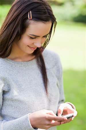 Relaxed young girl sending a text while standing in the countryside Stock Photo - Budget Royalty-Free & Subscription, Code: 400-06635554