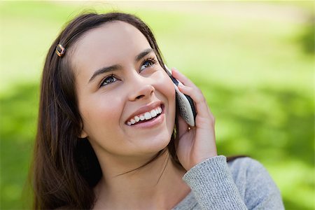Young smiling woman talking with her cellphone while looking up in the countryside Stock Photo - Budget Royalty-Free & Subscription, Code: 400-06635560
