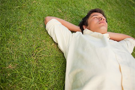 single man in arm of nature - Man lying in grass with his eyes closed and his hands resting underneath his head Stock Photo - Budget Royalty-Free & Subscription, Code: 400-06635869