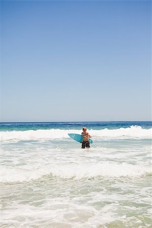 simsearch:400-05319489,k - Young blonde man returning to the beach while holding his surfboard Stock Photo - Budget Royalty-Free & Subscription, Code: 400-06636073