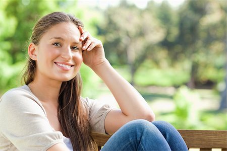 Smiling young woman on a bench in the park Stock Photo - Budget Royalty-Free & Subscription, Code: 400-06636322