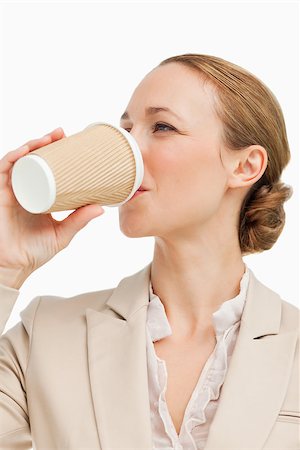 Businesswoman in a suit drinking a takeaway coffee against white background Stock Photo - Budget Royalty-Free & Subscription, Code: 400-06636534