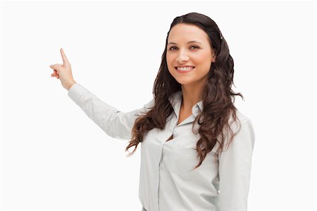 Portrait of a happy brunette pointing in her back white background Stock Photo - Budget Royalty-Free & Subscription, Code: 400-06636605