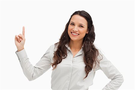 finger pointing up - Portrait of a brunette pointing up against white background Stock Photo - Budget Royalty-Free & Subscription, Code: 400-06636601