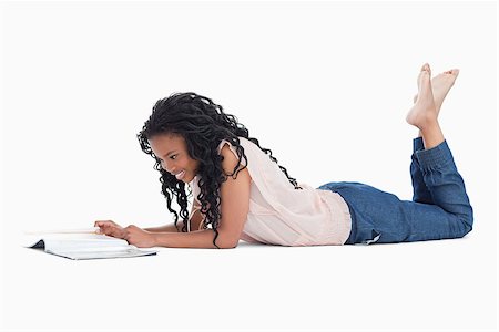 A young woman is lying on the floor reading a magazine against a white background Stock Photo - Budget Royalty-Free & Subscription, Code: 400-06636784