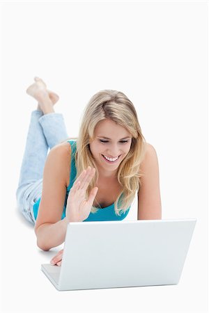 A woman with a laptop has her hand up and is lying on the floor against a white background Stock Photo - Budget Royalty-Free & Subscription, Code: 400-06636818