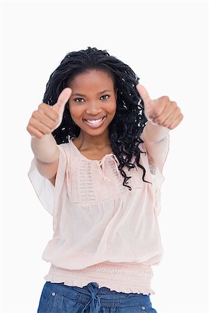 simsearch:400-06636885,k - A smiling woman who has her both thumbs up against a white background Photographie de stock - Aubaine LD & Abonnement, Code: 400-06636884