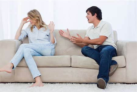 simsearch:400-06687238,k - A man sitting on a couch is having an argument with his girlfriend who has her head turned away Fotografie stock - Microstock e Abbonamento, Codice: 400-06637050