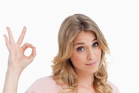 Relaxed young woman showing the ok sign against a white background Stock Photo - Budget Royalty-Free & Subscription, Code: 400-06637142