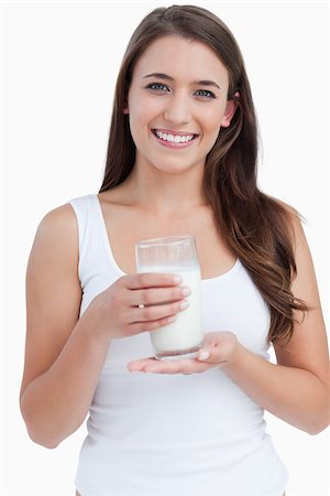 Smiling woman holding a glass of milk against a white background Stock Photo - Budget Royalty-Free & Subscription, Code: 400-06637449