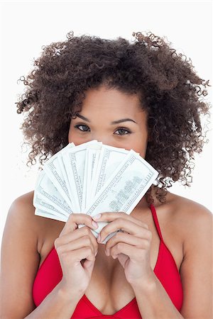 Brunette woman hiding her face behind a fan of notes against a white background Stock Photo - Budget Royalty-Free & Subscription, Code: 400-06637442