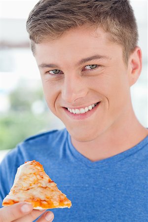 A close up shot of a smiling man looking at the camera as he gets ready to eat some pizza Stock Photo - Budget Royalty-Free & Subscription, Code: 400-06637858