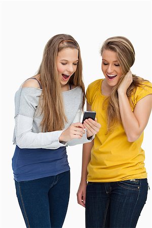 Two surprised students looking a cellphone screen against white background Stock Photo - Budget Royalty-Free & Subscription, Code: 400-06637932