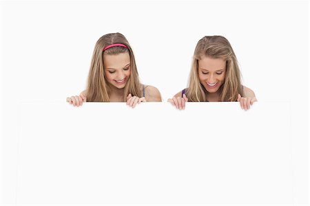 Close-up of two young women holding a blank board against white background Stock Photo - Budget Royalty-Free & Subscription, Code: 400-06638087