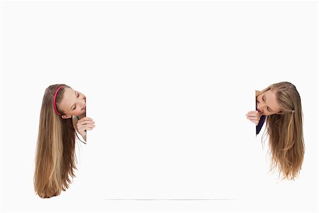 Two long hair young women behind a blank sign against white background Stock Photo - Budget Royalty-Free & Subscription, Code: 400-06638098