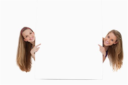 Portrait of two long hair women back of a blank sign against white background Stock Photo - Budget Royalty-Free & Subscription, Code: 400-06638100