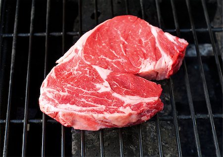 Raw steak cooking on a grill. Stock Photo - Budget Royalty-Free & Subscription, Code: 400-06638614