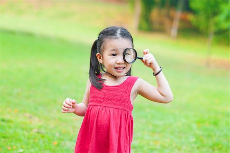 Little Asian girl exploring nature by magnifier glass Stock Photo - Budget Royalty-Free & Subscription, Code: 400-06639665