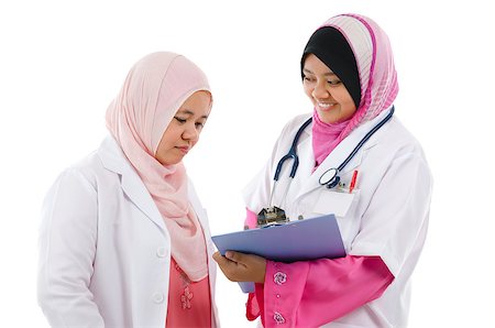 Two Southeast Asian Muslim medical doctors discussing on patient medical report, standing isolated on white background Stock Photo - Budget Royalty-Free & Subscription, Code: 400-06639670