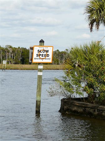 A Manatee Zone/Minimum Wake sign helps protect the endangered West Indian manatees from motorized boats in the Crystal River, Florida. Foto de stock - Super Valor sin royalties y Suscripción, Código: 400-06631978