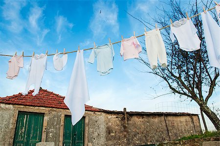 drying in the sun - baby clothes hanging on line outside in rural garden Foto de stock - Super Valor sin royalties y Suscripción, Código: 400-06632081