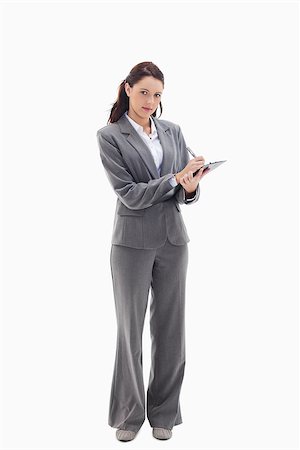 simsearch:400-06633122,k - Businesswoman writing on a clipboard against white background Stock Photo - Budget Royalty-Free & Subscription, Code: 400-06632208