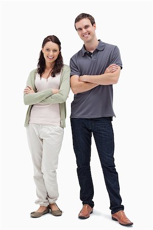 Smiling couple crossing their arms against white background Stock Photo - Budget Royalty-Free & Subscription, Code: 400-06632393