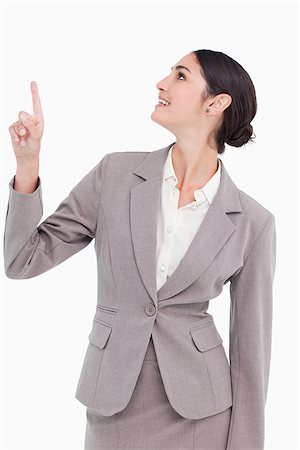finger pointing up - Smiling businesswoman looking and pointing up against a white background Stock Photo - Budget Royalty-Free & Subscription, Code: 400-06633073