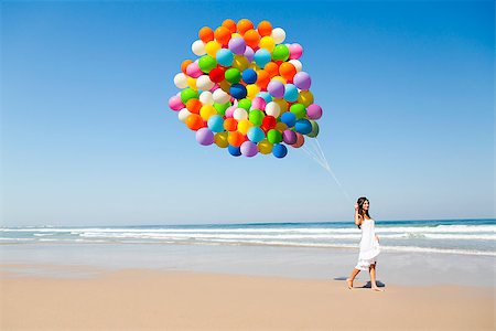 photo girl walking with balloon - Beautiful girl walking in the beach holding dozens of colored balloons Stock Photo - Budget Royalty-Free & Subscription, Code: 400-06633414