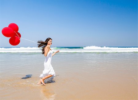Beautiful girl running in the beach with red ballons in her hand Stock Photo - Budget Royalty-Free & Subscription, Code: 400-06633415