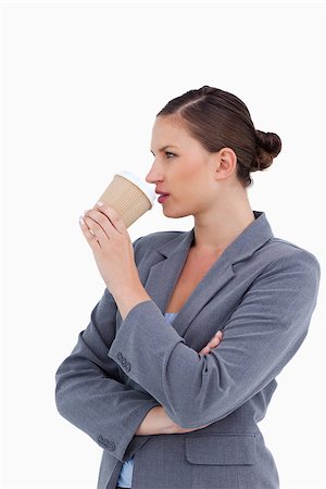 simsearch:400-06633122,k - Side view of tradeswoman taking a sip out of her paper cup against a white background Stock Photo - Budget Royalty-Free & Subscription, Code: 400-06633999