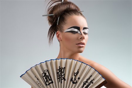 sexy brunette with japan make-up and asian fan, she looks down at left Stock Photo - Budget Royalty-Free & Subscription, Code: 400-06644254