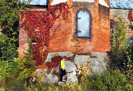 Female visitor explores Smokestack base of the Calumet and Hecla County Copper Mine in Calumet, Michigan.  She is leaning against concrete base with ash door above her. Photographie de stock - Aubaine LD & Abonnement, Code: 400-06644843