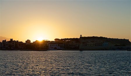 rethymno - Over the Greek city of Rethymno, the sun sets. His last rays soon disappear over the horizon. City and sea night falls the shadow. Photographie de stock - Aubaine LD & Abonnement, Code: 400-06640868