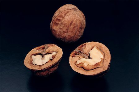 Halves of a walnut and the whole nut are a dark background Photographie de stock - Aubaine LD & Abonnement, Code: 400-06641648