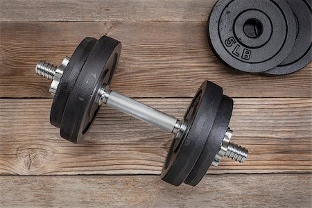 pixelsaway (artist) - exercise weights - iron dumbbell with extra plates on a wooden deck Foto de stock - Royalty-Free Super Valor e Assinatura, Número: 400-06642032